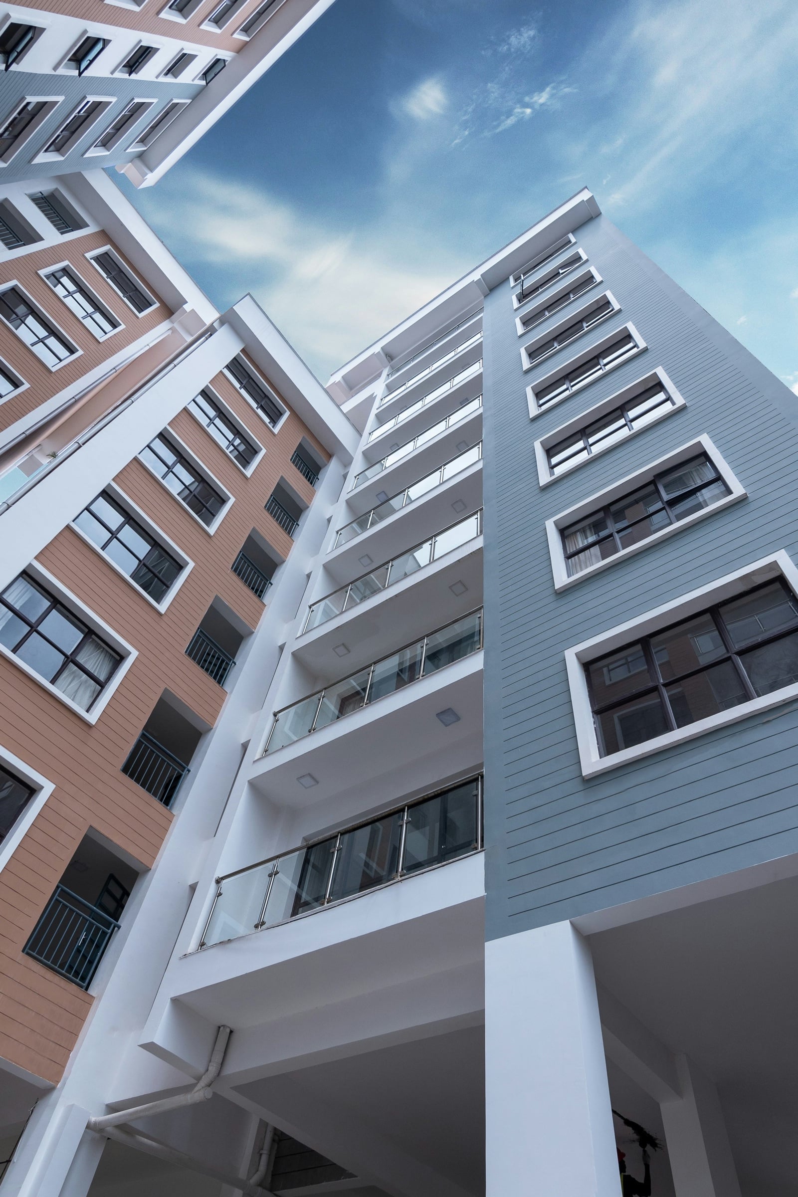 Apartment blocks with glass balconies at a residential development in Nairobi, seen from below.